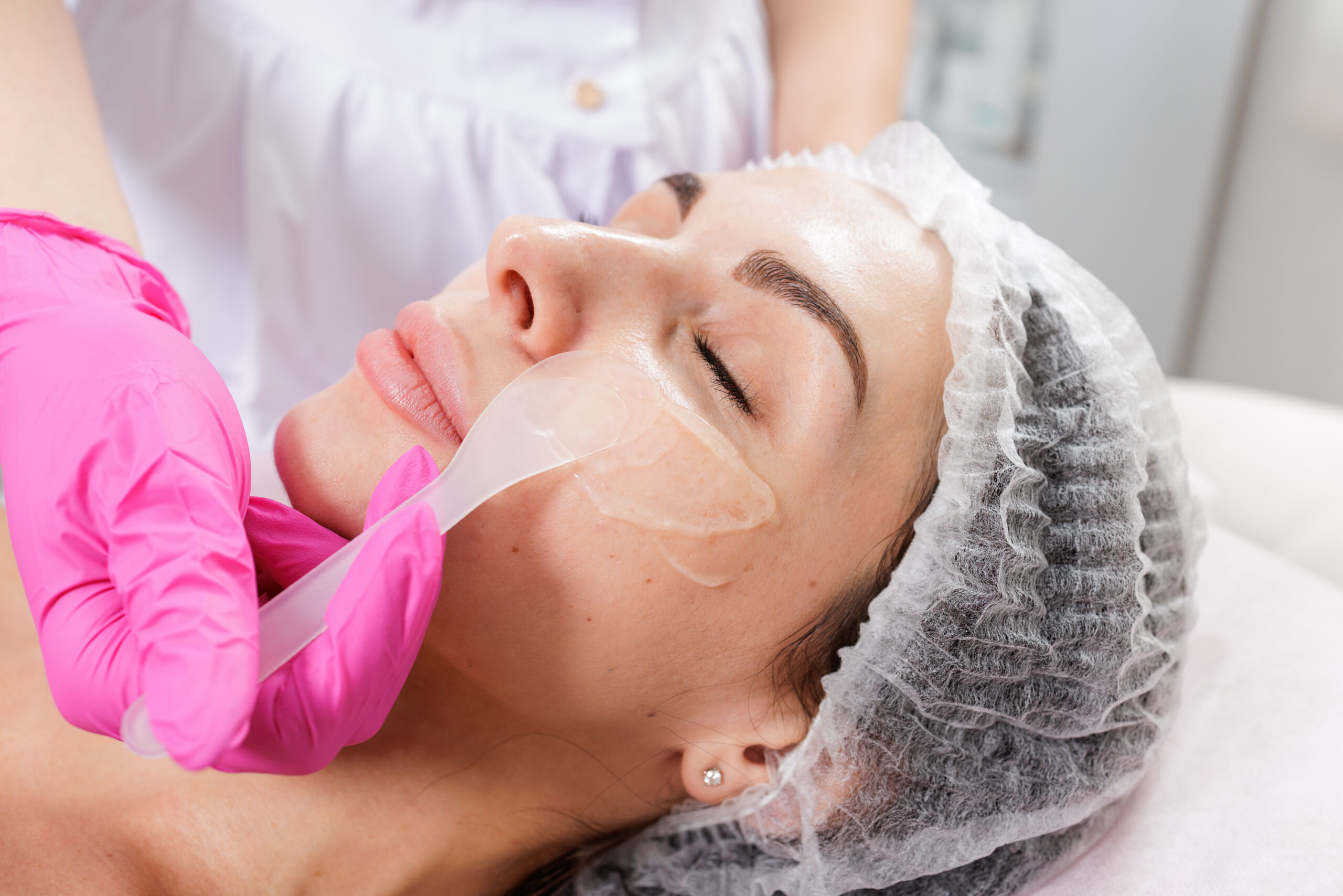 Cosmetologist applying gel before chemical peel treatment