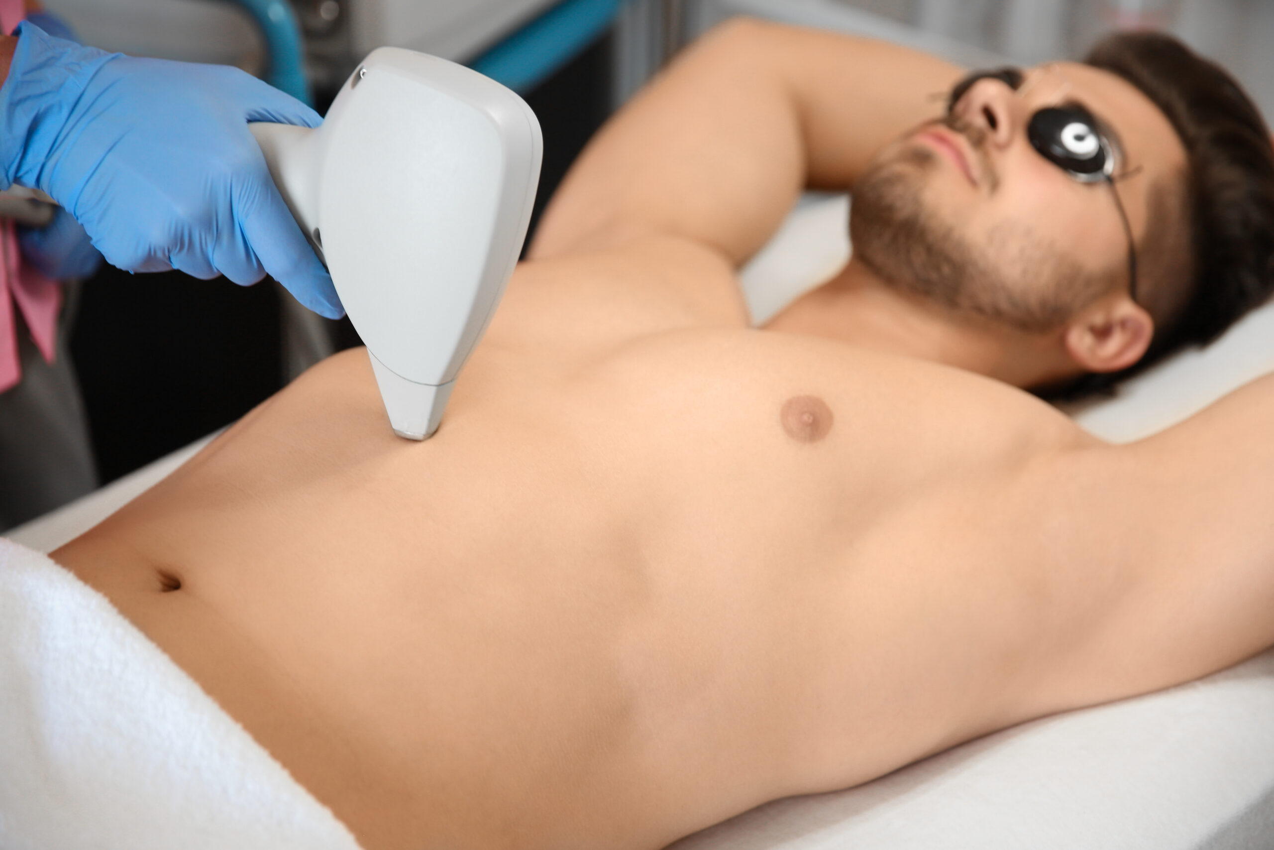 Man receiving laser hair removal on arms and chest